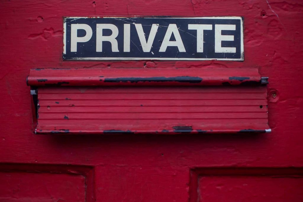 mail slot in a door with the word private above it